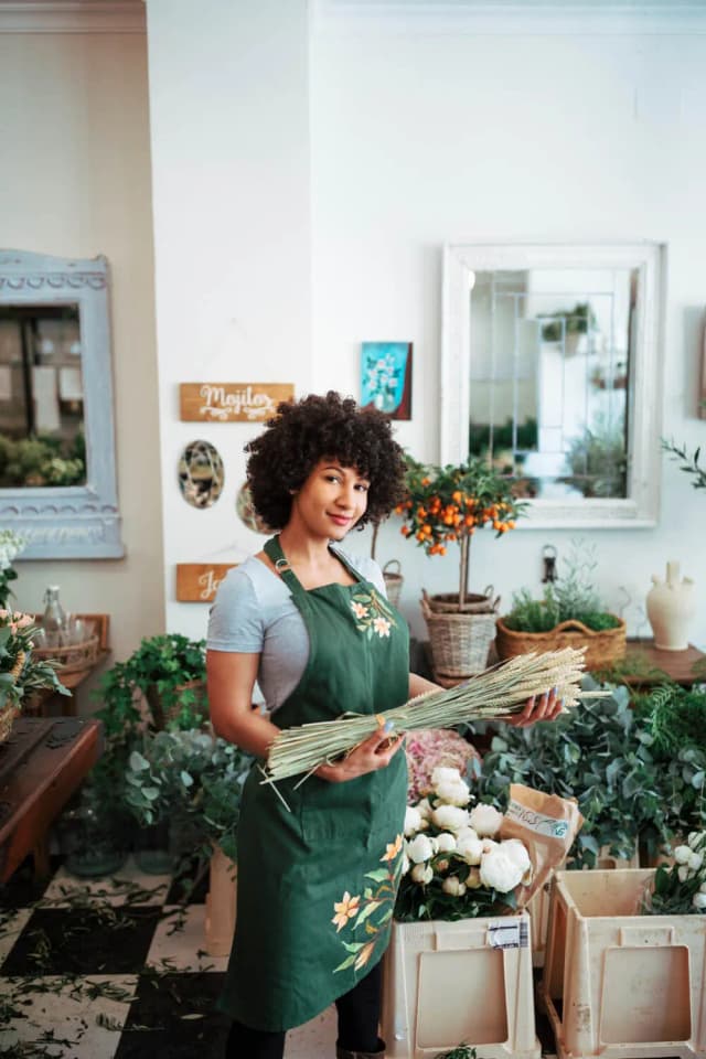 image of a local florist in her shop holding some flowers